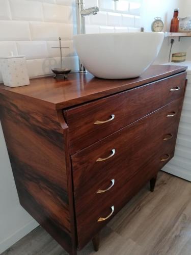 - une commode en bois avec un lavabo au-dessus dans l'établissement Le Grenier de Gaston, à Thouars-sur-Garonne