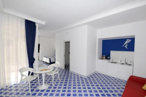 a living room with a table and chairs and a blue floor at Palazzo San Giovanni Amalfi Coast in Scala