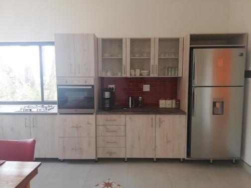 a kitchen with wooden cabinets and a refrigerator at Waterberg Guest Farm in Waterberg National Park