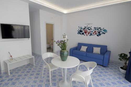 a living room with a table and a blue couch at Palazzo San Giovanni Amalfi Coast in Scala