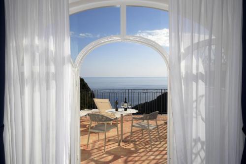 an open door to a balcony with a table and chairs at Palazzo San Giovanni Amalfi Coast in Scala