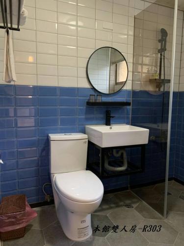 a bathroom with a white toilet and a sink at At Tainan Inn in Tainan