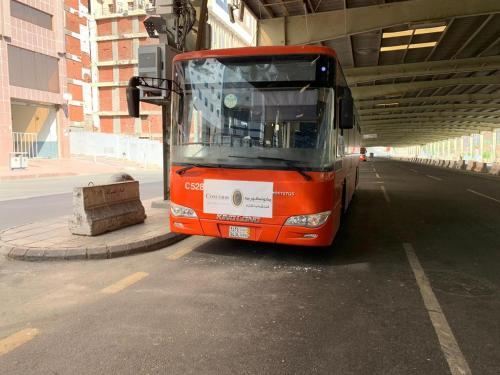 an orange bus parked on the side of a street at Bab Al Multazam Concorde Hotel in Makkah