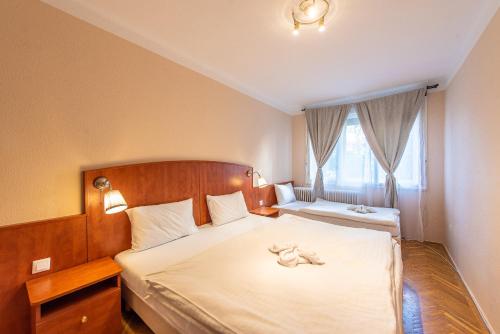 a bedroom with a bed with a stuffed animal on it at Korona Panzió Budapest in Budapest