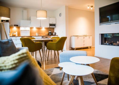 a kitchen and living room with tables and chairs at Apartmenthaus Feldberg in Feldberg