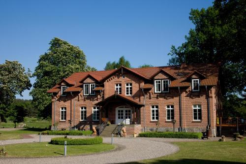 a large brick building with a roof at Gut Settin am See - Ferienhäuser in Settin