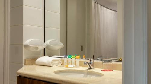 a bathroom with a sink and a mirror at Suite Comfort Apartments by Time Hotel & Apartments in Santiago