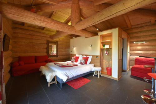 a bedroom with a bed and a red couch at Les Chalets de Maramour in Chazey-sur-Ain