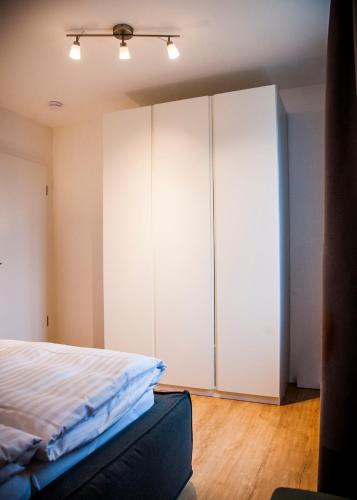 a bedroom with white cabinets and a bed at Apartmenthaus Feldberg in Feldberg