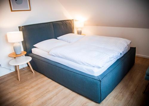 a large bed in a room with two lamps at Apartmenthaus Feldberg in Feldberg