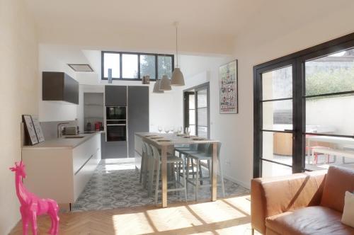 une cuisine et un salon avec une table et des chaises dans l'établissement L'Echoppe - Maison 3 chambres avec 2 salles de bain et grande Terrasse, à Talence