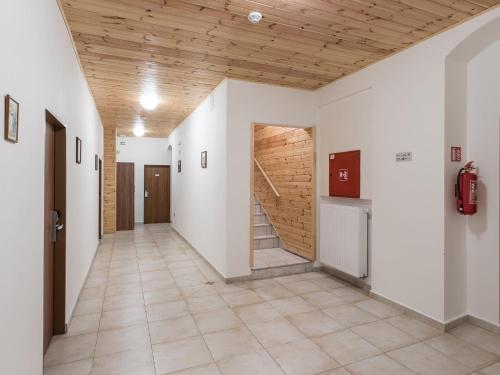a hallway with white walls and a wooden ceiling at EA Horský Hotel Hájenka in Modrava