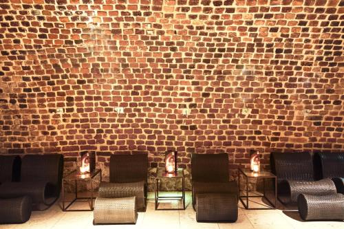 a brick wall with a row of chairs and candles at Hotel Stary in Kraków