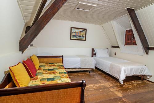 a bedroom with two beds and a couch in it at Pousada Estalagem de Brotas in Brotas