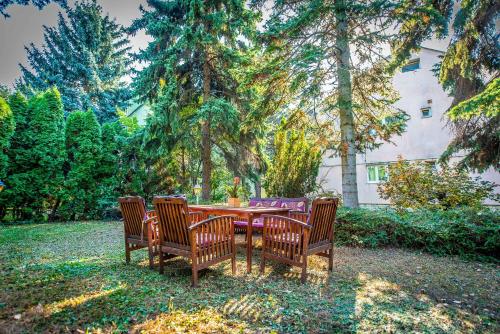 a table with three chairs around it in a yard at Korona Panzió Budapest in Budapest