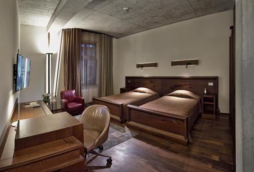 a bedroom with two beds and a desk and a chair at Hotel Stary in Kraków