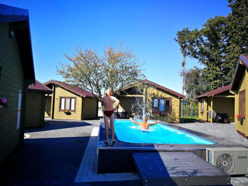 a man standing on a platform next to a swimming pool at Resort Baure in Palanga