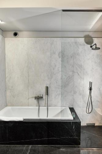 a bath tub in a bathroom with a wall at Hotel Stary in Kraków