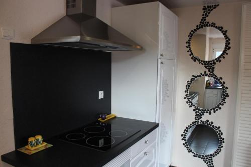 cocina con encimera negra y espejo en Au chalet d'Yport, en Yport