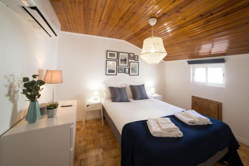リスボンにあるFLH Bairro Alto Charming Apartmentの木製の天井が特徴のベッドルーム1室(ベッド2台付)