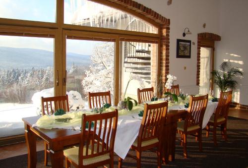Hotel Podlesí في Podlesí: غرفة طعام مع طاولة وكراسي ونافذة