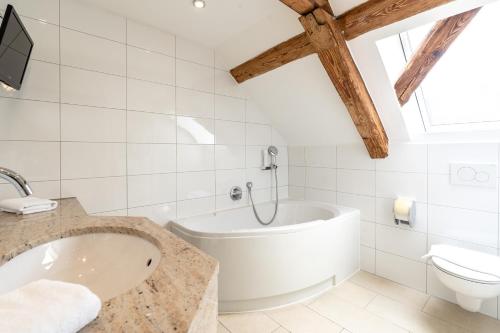 a white bathroom with a tub and a toilet at Weichandhof in Munich