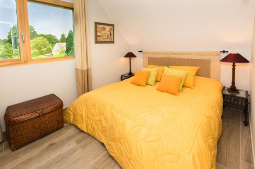 - une chambre avec un grand lit jaune et des oreillers jaunes dans l'établissement La Prairie, à Varengeville-sur-Mer