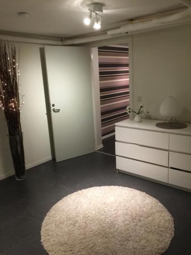 a living room with a white rug and a dresser at Lägenhet centralt i Värnamo vid Apladalen in Värnamo