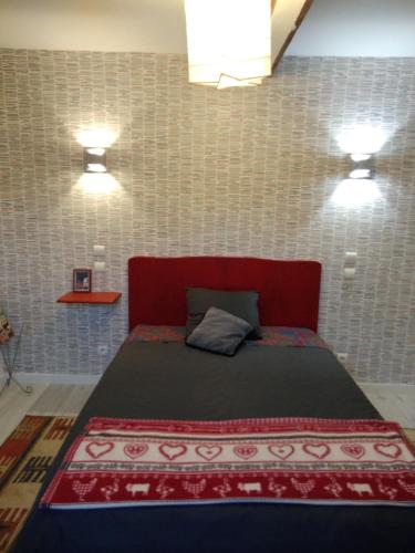 a bedroom with a red bed with two lights on it at CHAMBRES D'HOTES in Loudéac