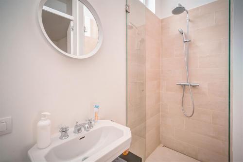 a bathroom with a sink and a shower with a mirror at The Greenplace Lodge. Apartment in Heart of Antwerp. in Antwerp