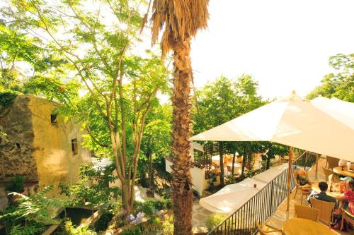a patio with an umbrella next to a palm tree at Alberi del Paradiso in Cefalù