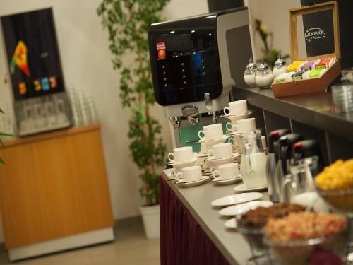 a counter with cups and plates of food at EA Business Hotel Jihlava in Jihlava