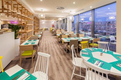 a restaurant with tables and chairs and a view of the city at Abora Interclub Atlantic by Lopesan Hotels in San Agustin
