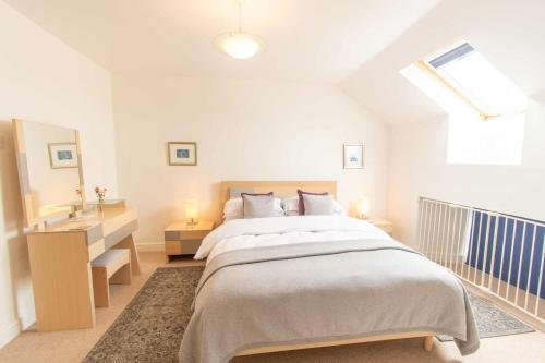 a white bedroom with a large bed and a window at Ardnave in Port Charlotte