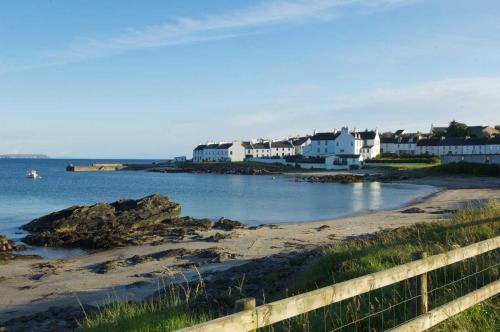 a view of a beach with houses and the ocean at Ardnave in Port Charlotte
