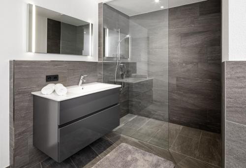 W łazience znajduje się umywalka i prysznic. w obiekcie lake and mountains appartements w mieście Maishofen
