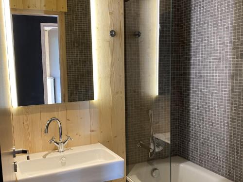 La salle de bains est pourvue d'un lavabo, d'un miroir et d'une baignoire. dans l'établissement Lagrange Vacances L’Écrin du Badet, à Aragnouet