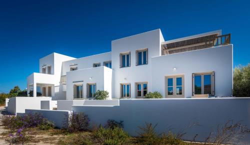 a white building with blue skies in the background at Milia Gi Suites in Pollonia