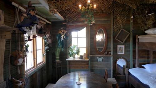 a room with a table and a bed and windows at Fide Äventyrsby & Camping in Fidenäs