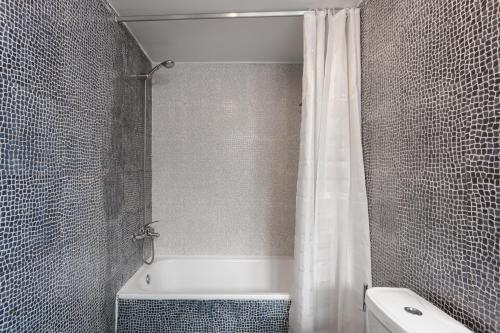 uma casa de banho com um chuveiro, uma banheira e um WC. em FLH Baixa Trendy Apartment em Lisboa