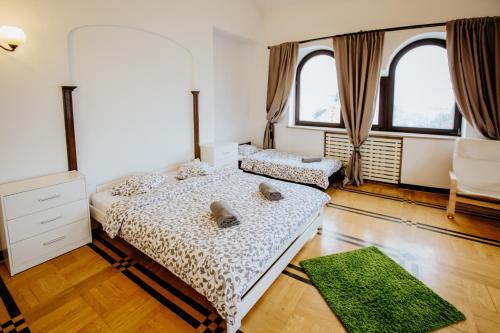 two beds in a room with two windows at Green Wood Apartament Stara Ochota in Warsaw