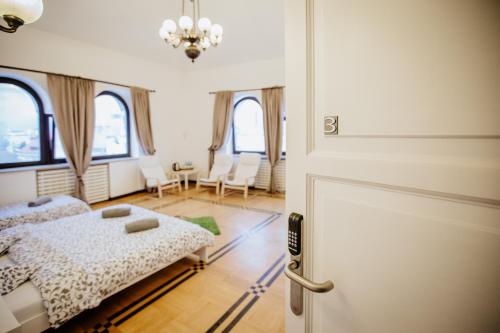 a bedroom with a bed and a door with a room with windows at Green Wood Apartament Stara Ochota in Warsaw