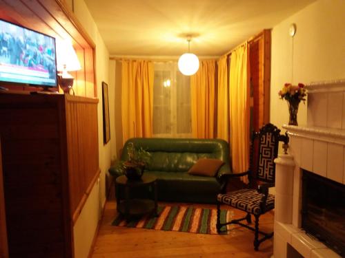 a living room with a green couch and a television at White Villa in Tallinn