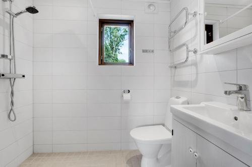 ein weißes Bad mit einem WC und einem Waschbecken in der Unterkunft Fide Äventyrsby & Camping in Fidenäs
