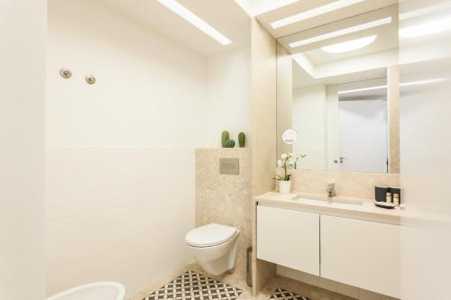 a white bathroom with a toilet and a sink at FLH Chiado Sunny Apartment in Lisbon