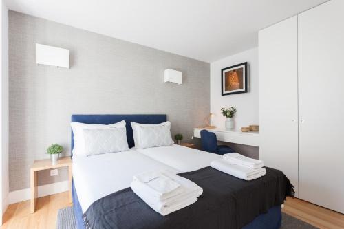 リスボンにあるFLH Chiado Elegant Apartmentのベッドルーム1室(大型ベッド1台、タオル2枚付)