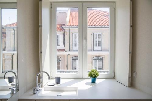 a kitchen with a window with a sink and a plant at FLH Downtown Amazing Flat in Lisbon
