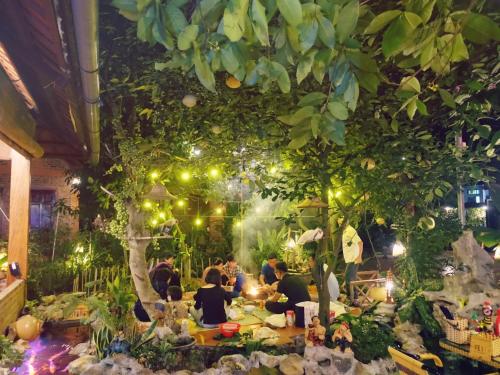 a group of people sitting at a table under a tree at Trang An Village Homestay in Ninh Binh