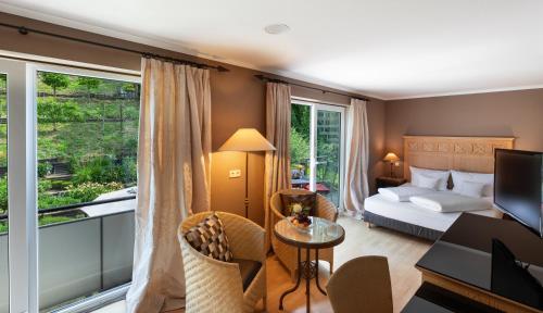 a hotel room with a bed and a desk and a table at Romantik Hotel Residenz am See in Meersburg