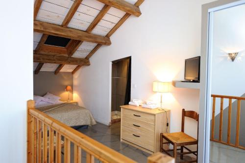 a bedroom with a bed and a television and a staircase at Appartement du Tourisme in Zonza